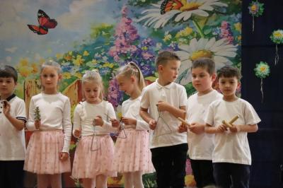 Przedszkolaki w kolorowych strojach występują na scenie z okazji Święta Rodziny