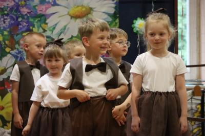 Przedszkolaki w kolorowych strojach występują na scenie z okazji Święta Rodziny