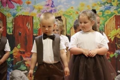 Przedszkolaki w kolorowych strojach występują na scenie z okazji Święta Rodziny