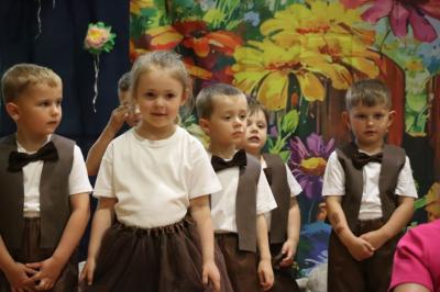 Przedszkolaki w kolorowych strojach występują na scenie z okazji Święta Rodziny