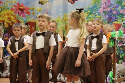 Przedszkolaki w kolorowych strojach występują na scenie z okazji Święta Rodziny
