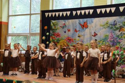 Przedszkolaki w kolorowych strojach występują na scenie z okazji Święta Rodziny