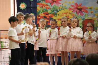 Przedszkolaki w kolorowych strojach występują na scenie z okazji Święta Rodziny
