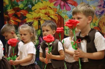 Przedszkolaki w kolorowych strojach występują na scenie z okazji Święta Rodziny