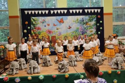 Przedszkolaki w kolorowych strojach występują na scenie z okazji Święta Rodziny
