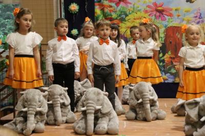 Przedszkolaki w kolorowych strojach występują na scenie z okazji Święta Rodziny