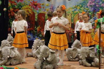 Przedszkolaki w kolorowych strojach występują na scenie z okazji Święta Rodziny
