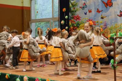 Przedszkolaki w kolorowych strojach występują na scenie z okazji Święta Rodziny