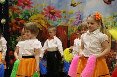 Przedszkolaki w kolorowych strojach występują na scenie z okazji Święta Rodziny