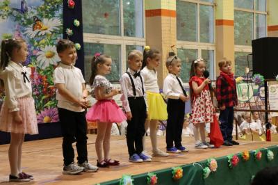 Przedszkolaki w kolorowych strojach występują na scenie z okazji Święta Rodziny