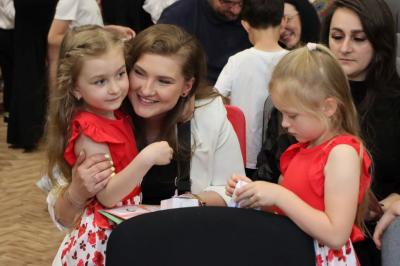Rodzice siedzący na widowni ogladają występ dzieci