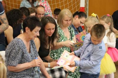 Rodzice siedzący na widowni ogladają występ dzieci