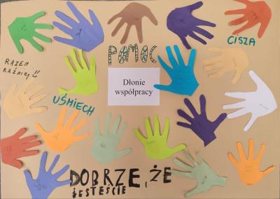 Plakat z wyciętymi dłońmi.