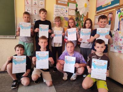 Uczniowie pozują do zdjęcia z dyplomam