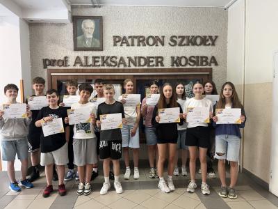 uczniowie klasy patronackiej etwinning na zdjęciu trzymają dyplomy