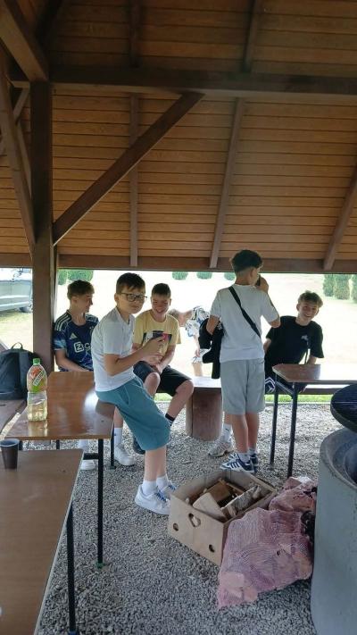 chłopcy rozmawiają przy palenisku