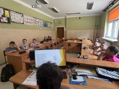 uczeń z klasy 8 czyta prezentację z wycieczki do Londynu kolegom z klasy 4a
