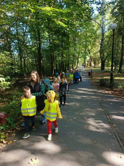 przedszkolaki spacerują po parku