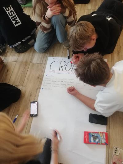 grupka uczniów tworzy plakat o Chorwacji w języku angielskim