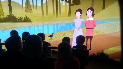 Dzieci oglądają film na dużym ekranie w jednej z sal muzeum.