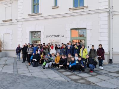 Uczestnicy wycieczki stoją na tle budynku Etnocentrum Ziemi Krośnieńskiej