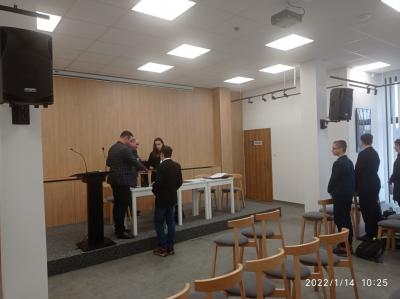 Uczeń Ksawery Szary odbiera z rąk Przewodniczącego Rady Miejskiej pana Grzegorza Nosala akt ślubowania wraz z drobnym upominkiem.