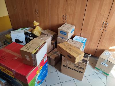 Gotowe dary dla uchodźców z Ukrainy, pudełka podpisane tematycznie poskładane na podłodze.