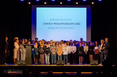 Na scenie stoją wszyscy nagrodzeni laureaci tegorocznej Gali Anioły Wolontariatu 2022 wraz z przedstawicielami władz samorzadowych powiatu gorlickiego.
