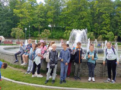 Dzieci stoją obok fontanny na deptaku w Krynicy