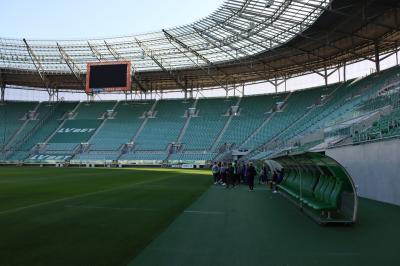 Uczniowie zwiedzają stadion śląski. Wszyscy podziwiaja murawę oraz trybuny.