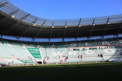 Uczniowie zwiedzają stadion śląski. Wszyscy podziwiaja murawę oraz trybuny.