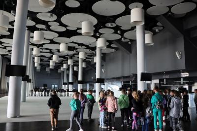 Uczniowie zwiedzają stadion śląski. Zwiedzanie pomieszczenia restauracyjnego.