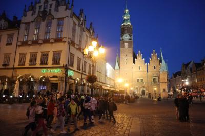 Uczniowie zwiedzają centrum Wrocławia. Spacer po rynku w wieczorowej porze.