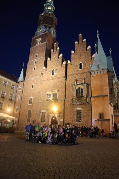 Uczniowie zwiedzają centrum Wrocławia. Spacer po rynku w wieczorowej porze.