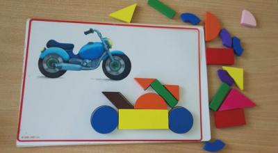 Gra edukacyjna - rysunek motocykla oraz obok klocki do ułożenia rysunku motocykla.