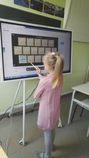 Uczeń obsługuje interaktywny program na monitorze dotykowym