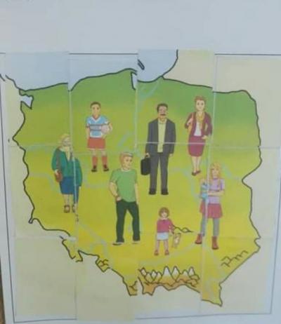 Zdjęcie mapy Polski wyświetlane na interaktywnym monitorze. Na konturze Polski umieszczone są postacie ludzi.