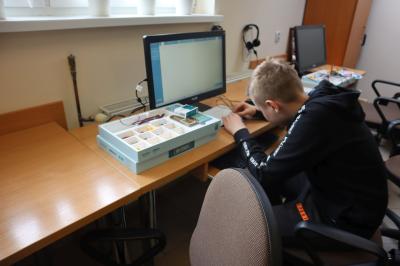 Uczniowie klasy VIb uczestniczą w zajęciach mechatroniki. Na stołach umieszczone są zestawy do nauki mechatroniki