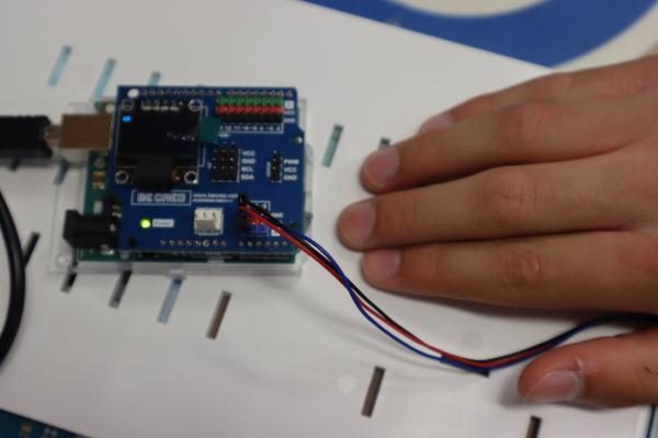 Płytka Arduino wyświetlająca dane. Obok dłoń.
