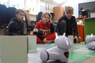 Uczniowie programują robotą jeźdżącego po macie miasta