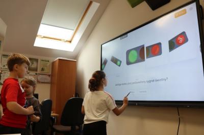 Uczniowie obsługują monitor interaktywny.