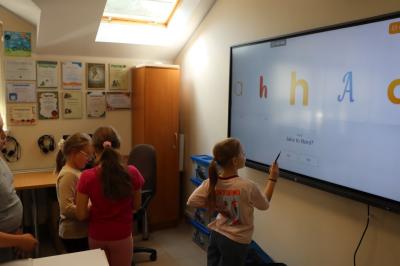 Uczniowie obsługują monitor interaktywny.