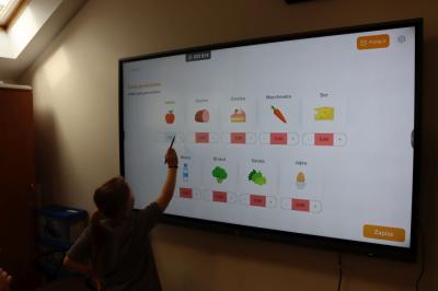 Uczniowie obsługują monitor interaktywny.